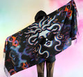 Pashmina with Medusa Untamed design being held behind and fully spread out to show the design